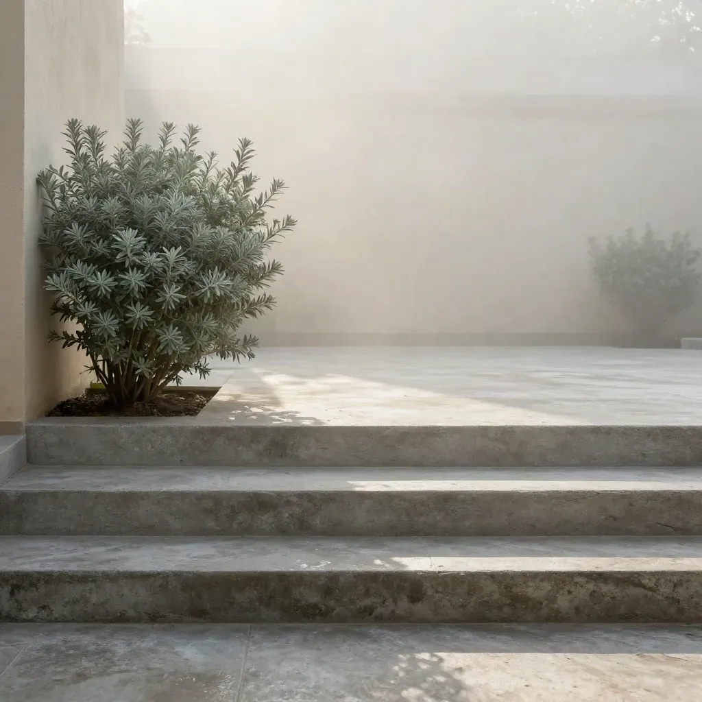 Patio ajardinado com degraus de concreto, arbusto podado e névoa suave ao amanhecer